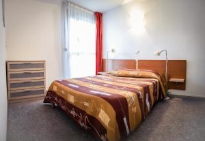 - une chambre avec un lit et une grande fenêtre dans l'établissement Les Pavillons du Rooy, à Salies-de-Béarn