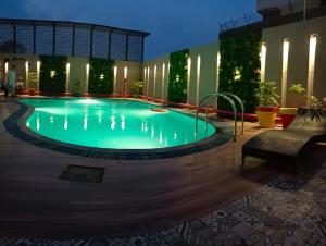 Surasena Regal Vista Agra في آغْرا: مسبح في فندق بالليل