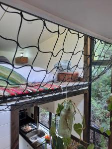 a shelf in a kitchen with a sink and a window at Tiny Home Trails End in Lovemore Park