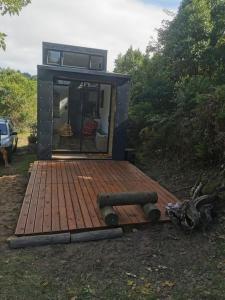 a tiny house sitting on top of a wooden deck at Tiny Home Trails End in Lovemore Park