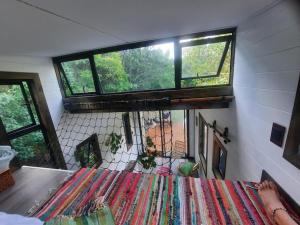 a room with two windows and a table with a rug at Tiny Home Trails End in Lovemore Park