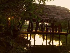 un tavolo e sedie su un molo in acqua di Aliya Riverside & Safari Resort a Udawalawe