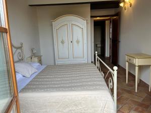 ein Schlafzimmer mit einem großen Bett und einer Tür in der Unterkunft Valle del Metauro Country House in Montemaggiore al Metauro