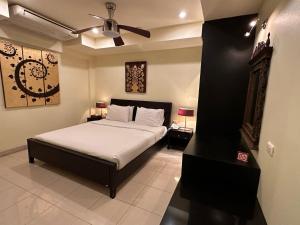um quarto com uma cama e uma ventoinha de tecto em Copa Hotel em Pattaya Central