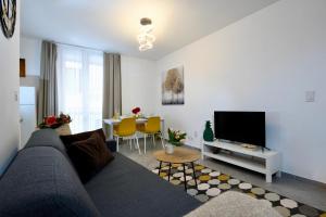 un soggiorno con divano, TV e tavolo di Aria Apartment - Free Parking a Bioggio