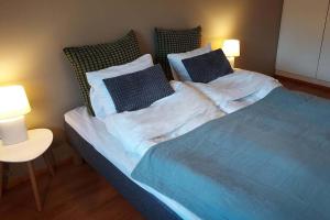 a bedroom with a blue bed with two lamps at Cosy two rooms apartment in Helsinki in Helsinki