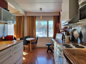 uma cozinha com um fogão, uma mesa e uma janela em Cosy two rooms apartment in Helsinki em Helsinque
