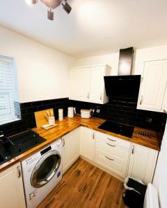 cocina con armarios blancos y lavadora en Two Double bedrooms apartment near Hull city centre en Hull