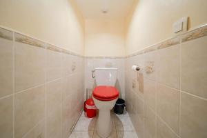 a bathroom with a toilet with a red lid at appartement 30m2 calme proche du centre ville in Lunel