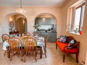 uma cozinha e sala de jantar com mesa e cadeiras em Villa Fieldend - Gozo Holiday Home em Għarb