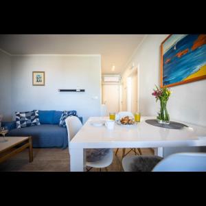 een woonkamer met een witte tafel en een blauwe bank bij Apartman Megi in Dubrovnik