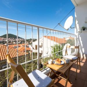 een balkon met een tafel en stoelen op een balkon bij Apartman Megi in Dubrovnik