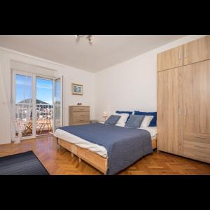 een slaapkamer met een groot bed en een houten kast bij Apartman Megi in Dubrovnik +35 foto's