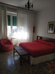 una camera con letto rosso e sedia di Grande casa vicina al centro a Firenze