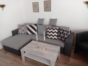 uma sala de estar com um sofá cinzento e uma mesa em Sommerheide em Bad Bevensen