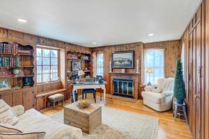 a living room with wooden walls and a fireplace at Classic Brookfield Home about 14 Mi to Milwaukee! in Brookfield