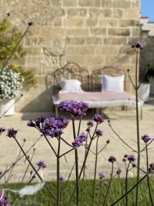 Un mazzo di fiori viola davanti a un letto di Masseria Spartivento a Conca Specchiulla