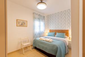 a bedroom with a bed with a chair and a window at San Vicente Apartamento, 5 pax, Centro Historico in Seville