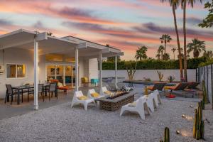 Ein Haus mit einer Terrasse mit einem Tisch und Stühlen in der Unterkunft For The Record in Palm Springs