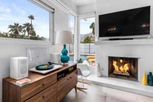 sala de estar con chimenea y TV en For The Record en Palm Springs