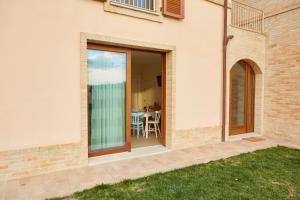 a sliding glass door leading to a patio with a table at Agriturismo Nido delle Rondini in Macerata