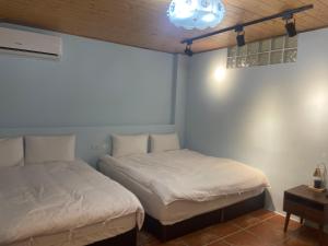 um quarto com 2 camas e um candeeiro em See Hualien Homestay em Hualien