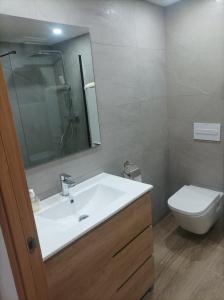 ein Badezimmer mit einem weißen Waschbecken und einem WC in der Unterkunft Piso 1ª Línea Y Céntrico in Peñíscola