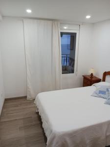 1 dormitorio con cama blanca y ventana en Piso 1ª Línea Y Céntrico, en Peñíscola