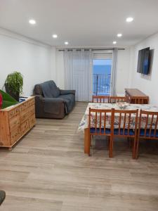 ein Wohnzimmer mit einem Tisch und einem Sofa in der Unterkunft Piso 1ª Línea Y Céntrico in Peñíscola