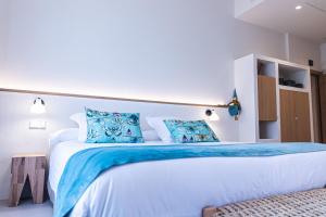 una camera da letto con un grande letto bianco con cuscini blu di Hotel Monells Summum a Monells