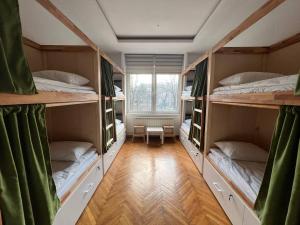 Zimmer mit 4 Etagenbetten und einem Fenster in der Unterkunft Cabbage Hostel in Belgrad