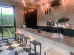 a restaurant with a bar with stools and a window at Sp3 Hotel in Ban Na