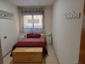 a small bedroom with a bed and a window at Apartamento Murcia in Murcia
