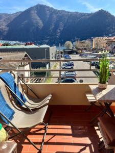 un balcón con sillas y mesas y un aparcamiento en Como Lake House, vista lago: 100 mt dal lago, en Como