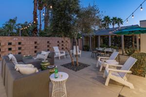 a patio with a couch and chairs and tables at On The Rocks in Palm Springs