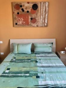 1 cama con 2 almohadas y una pintura en la pared en Como Lake House, vista lago: 100 mt dal lago, en Como