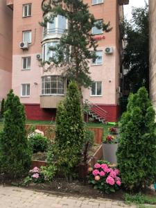 een gebouw met bomen en bloemen ervoor bij Samal-2 Hotel in Alma-Ata