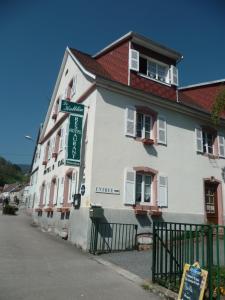 a white building with a sign in front of it at Hotel Restaurant Du Kalblin in Fréland