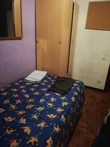 a bed with a blue comforter with a laptop on it at HAB room 1 WIFI Vista Alegre in Madrid
