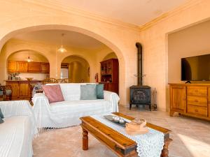 a living room with a white couch and a fireplace at Villa Fieldview - Gozo Holiday Home in Għarb