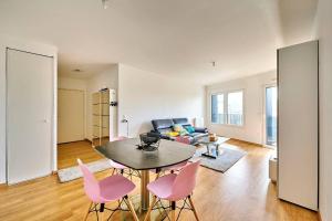 salon ze stołem i różowymi krzesłami w obiekcie Magnifique F3 à moins de 15 min de la défense w mieście Nanterre