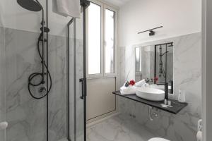 a white bathroom with a sink and a shower at Re di Roma Rooftop in Rome