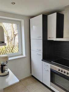 a kitchen with white cabinets and a window at Ferienwohnung Elbtraum in Pirna