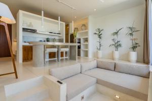 ein Wohnzimmer mit einem Sofa und einer Küche in der Unterkunft Sore Apartment by Hombali in Canggu