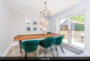 a dining room with a wooden table and green chairs at Luxury Tydd St Giles Holiday Rental in Tydd Saint Giles