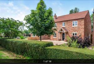a brick house with a tree in the yard at Luxury Tydd St Giles Holiday Rental in Tydd Saint Giles