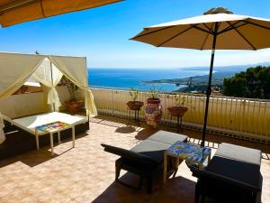 a patio with an umbrella and a table and chairs at Villa Greta Hotel Rooms & Suites in Taormina