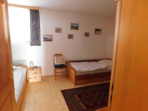 ein Schlafzimmer mit einem Bett, einem Stuhl und einem Fenster in der Unterkunft Ferienwohnungen Jagerhüttn in Hochrindl