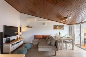ein Wohnzimmer mit einem Sofa und einem Tisch in der Unterkunft THE ATTIC - Caparica Beach and Surf Apartment in Costa da Caparica