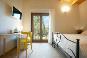 a bedroom with a bed and a desk and a window at Agriturismo Nido delle Rondini in Macerata